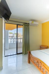 1 dormitorio con 1 cama y balcón en Hotel Costa mar, en Barranquilla