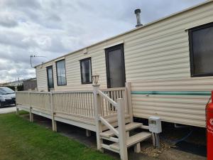 a white mobile home with a porch and a staircase at 4 Berth Golden Sands Ingoldmells (Siesta) in Ingoldmells