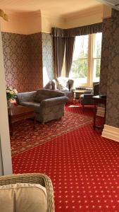 a living room with couches and a red carpet at Thornton Lodge in Aysgarth