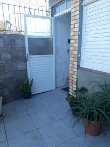 une porte de garage avec deux plantes devant elle dans l'établissement APARTAMENTOS POR DIÁRIA Av DOMINGOS DE ALMEIDA, à Pelotas