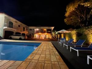 a villa with a swimming pool at night at Dom Ravello in Telêmaco Borba