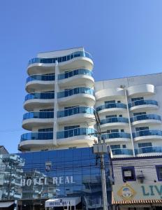 un edificio alto con ventanas azules en una calle en Hotel Real en Cabo Frío