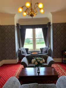 a living room with couches and a table and a window at Thornton Lodge in Aysgarth