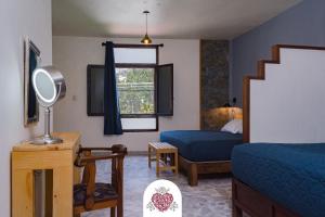 a bedroom with a bed and a chair and a mirror at Hotel Corazón de Plata Centro in Guanajuato
