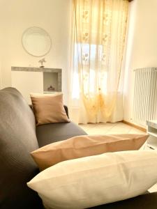sala de estar con sofá y ventana en Casa Roberto - piano terra con giardino, en Levico Terme
