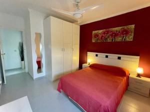 ein Schlafzimmer mit einem Bett und einer roten Wand in der Unterkunft Casa con jardín y terraza 3 dormitorios in Los Alcázares