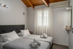 two beds in a bedroom with towels on them at Deifilia Villa in Pandokrátor +31 photos