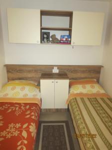 a small bedroom with two beds and a mirror at RAVA - Center of the World - place for relaxing in Rava