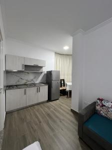 a kitchen with a refrigerator and a couch in a room at Red Rose Guest House in Golem
