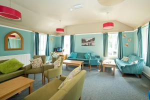 uma sala de estar com paredes e mobiliário azuis em YHA Malham em Malham