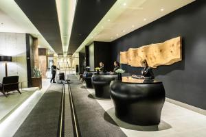 a lobby with a row of black chairs and people at Movich Buro 26 in Bogotá