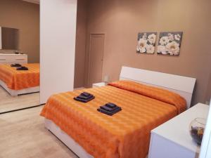 a bedroom with two beds with orange sheets at Happy Home in Pozzallo