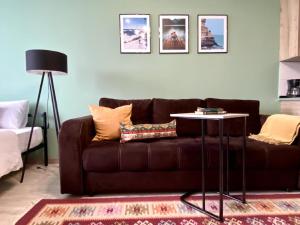 uma sala de estar com um sofá castanho e uma mesa em Апартаменты-студия Көктем с видом на город em Almaty