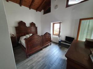 レッツェノにあるDelphina's houseのベッドルーム1室(大型木製ベッド1台、窓付)