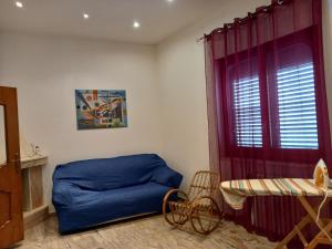 um quarto com uma cama azul e uma janela em Pensiero di mare em Taurisano