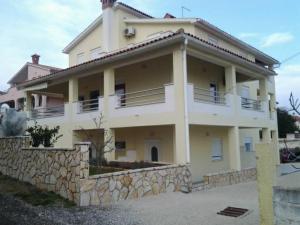 uma grande casa branca com uma parede de pedra em Apartment Celina em Ližnjan