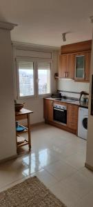 a kitchen with a table and a stove top oven at duplex appartement met zwembad, L'ampolla, in L'Ampolla