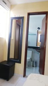 a bathroom with a mirror and a sink and a toilet at Suíte INDIVIDUAL com Ar condicionado em AP Compartilhado in João Pessoa +6 photos