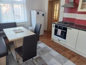 a kitchen with a table and a stove and refrigerator at Apartmány U Mariánské kaple in Česká Kamenice