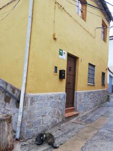 un edificio amarillo con una puerta a un lado en Casa Abuelo Lorenzo, en Enguídanos