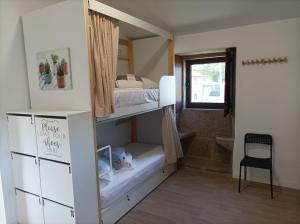 TeoAlbergue Aldea da Pedreira的一间有双层床和窗户的小房间