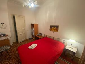 a red bed in a room with a red blanket at My Home Guest House in Baku
