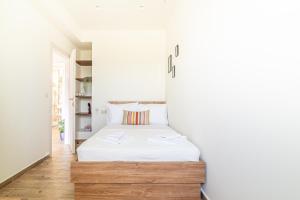 a bedroom with a white bed in a white wall at Cozy House with Pool near Beach in Gázion