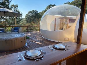 a table with plates and silverware on a wooden deck at La Estela Bubble Glamping in Mazamitla