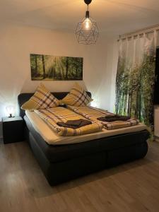 1 cama en un dormitorio con lámpara de araña en Ferienhaus-Weitsicht en Sankt Wendel