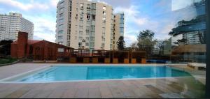 a large swimming pool in front of a tall building at Wind Tower Punta del Este in Punta del Este