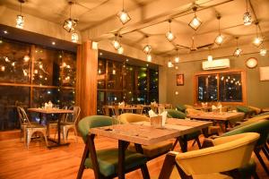 restauracja ze stołami, krzesłami i oknami w obiekcie SILVER REGENCY w mieście Guwahati