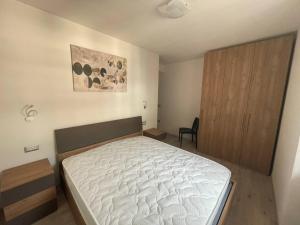 a bedroom with a bed and a wooden cabinet at Appartamenti ALICE MOLVENO in Molveno