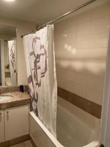 a bathroom with a tub and a shower curtain at Lisbonne in Algés