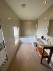 a bathroom with a tub, sink, and toilet in it at Garddfon Inn in Y Felinheli