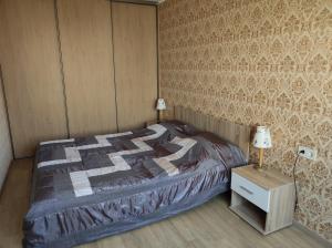 a bedroom with a bed and a table with a lamp at Apartment Südalinnas in Haapsalu