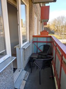 a balcony with two chairs and two windows at Apartment Südalinnas in Haapsalu