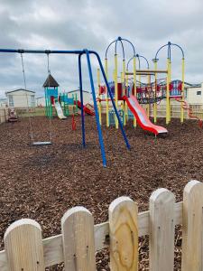 a playground with a slide and swings at Victory Coaster in Seasalter