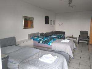 a hotel room with two beds and a chair at Veronika in Erftstadt