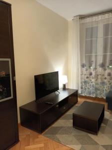 uma sala de estar com uma televisão de ecrã plano e uma mesa em Apartament w Sercu Starego Miasta em Olsztyn