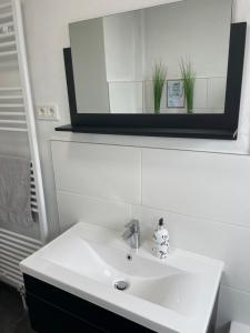 a bathroom with a white sink and a mirror at Ferienhaus-Weitsicht in Sankt Wendel