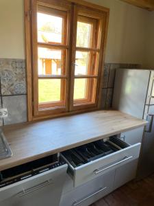 a wooden counter top in a kitchen with a window at Domy w Lipowie - dom żółty in Piecki