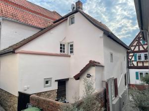 Casa blanca con techo rojo en Ferienwohnung Obergasse en Zwingenberg