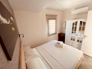 a white bedroom with a bed and a window at Naz Liman Otel Bodrum in Bodrum City