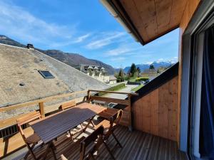 a wooden deck with a wooden table and chairs at La maison du lac in Doussard