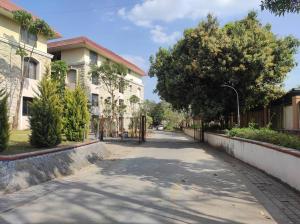 an empty street in a town with buildings and trees at 1BHK AC Service Apartment 103 in Pune