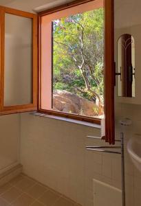 een badkamer met een raam en een wastafel bij Kirù Lovely Home - Villa Su Cuile, Cala Ginepro in Monte Petrosu +39 foto's