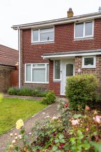 a red brick house with white windows and a yard at Bright & Cosy - Jacuzzi - Log Burner - King Beds in Tangmere