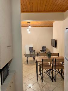 - une salle à manger avec une table, des chaises et une télévision dans l'établissement Sofia's House, à Sývota