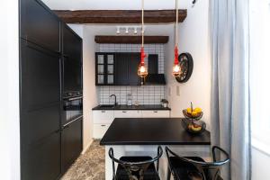 a kitchen with black cabinets and a black table and chairs at Casa Ogo in Zadar