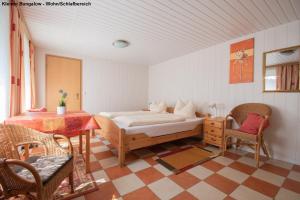 a bedroom with a bed and a table and chairs at Kleiner Bungalow - Zum Strand 50m in Ueckeritz